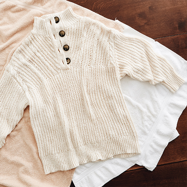 An Aerie sweater drying flat on a clean towel.