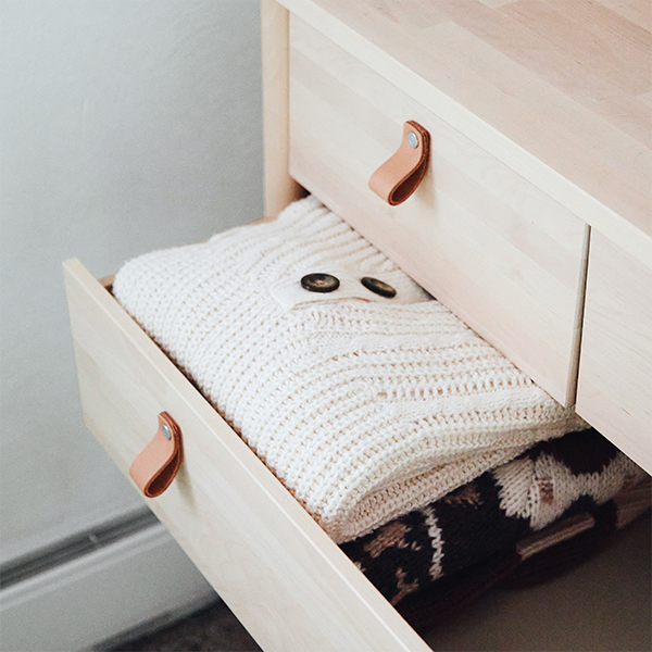 Folding an Aerie sweater in a drawer.
