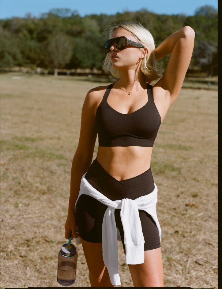 Woman wearing a brown OFFLINE by Aerie sports bra.