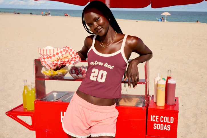 Woman in Aerie tank top and shorts on the beach.