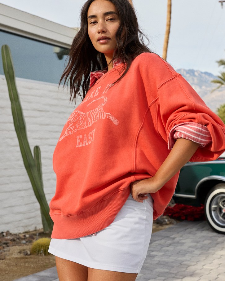Woman wearing a white skort and Aerie crewneck.