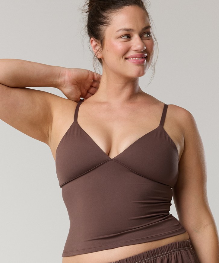 Woman in a brown braless tank top.