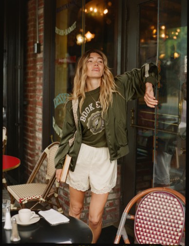 Woman wearing Aerie sweatshirt, jacket and shorts.