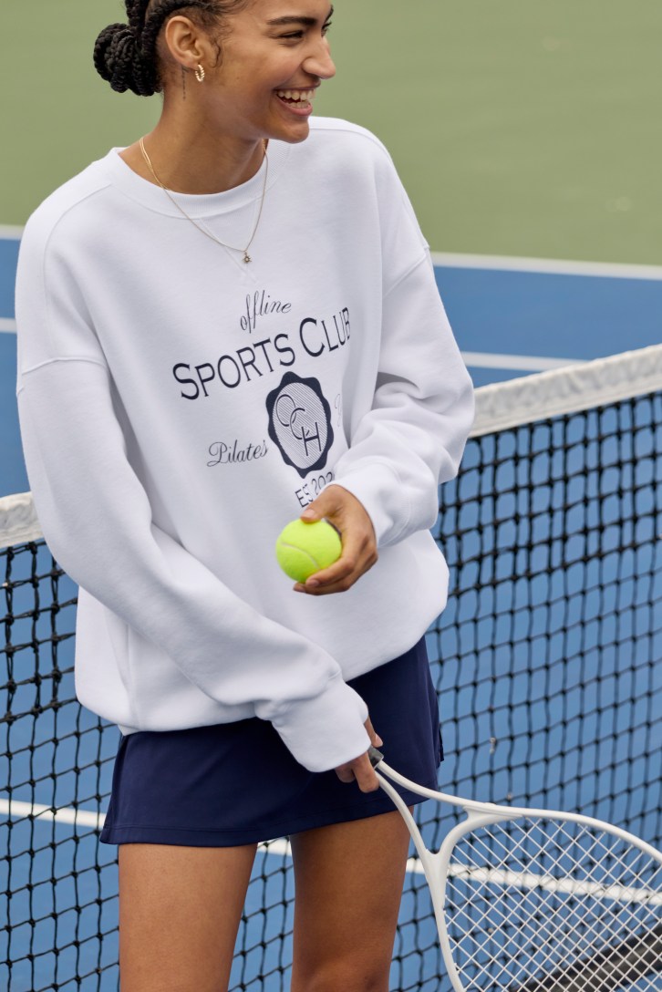 Woman wearing tennis outfit and hoodie from Aerie.
