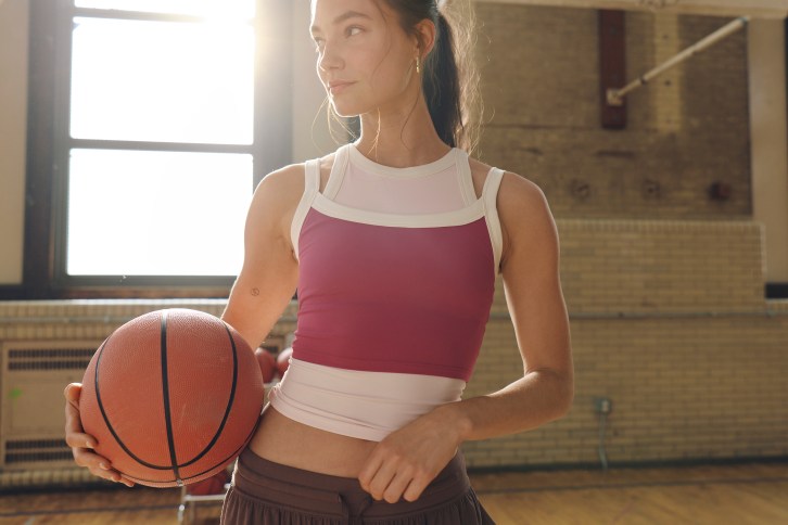 Woman wearing a sports bra holding a basketball.