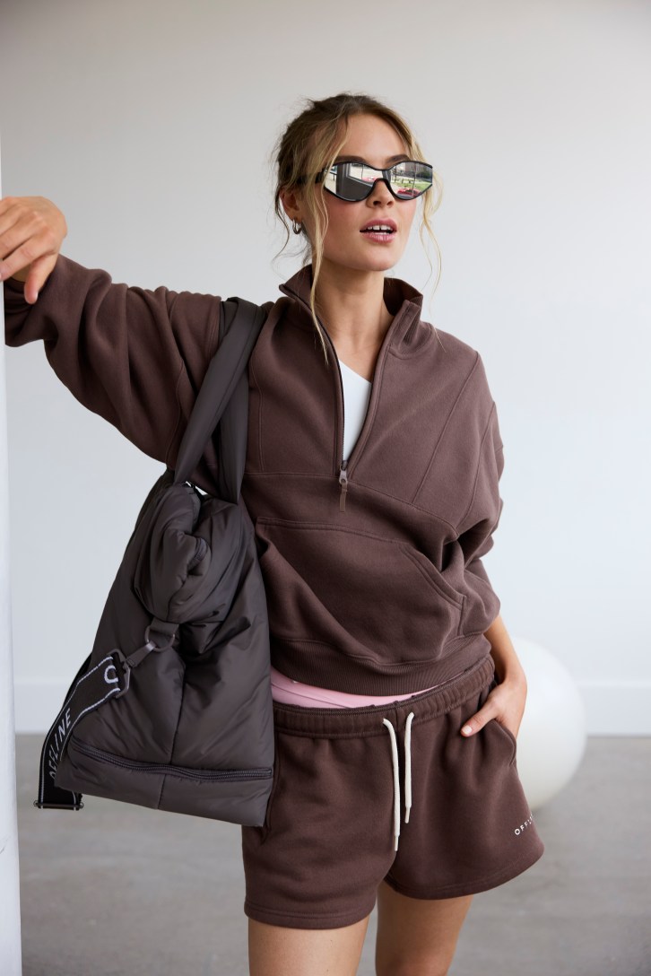 Woman wearing a brown sweatshirt with a pocket.