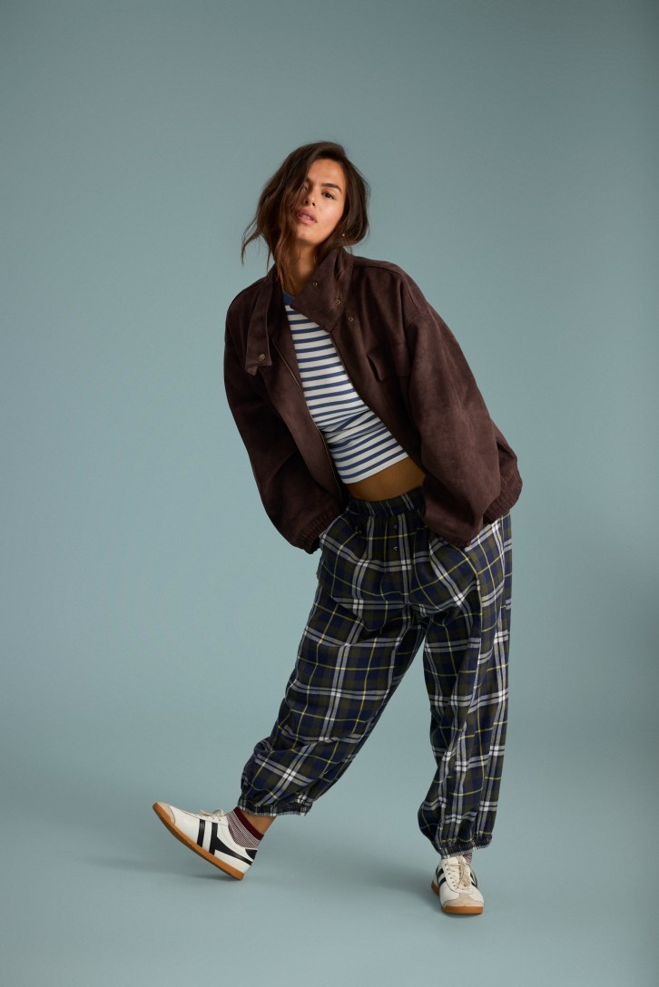 Woman wearing a jacket and flannel pants.