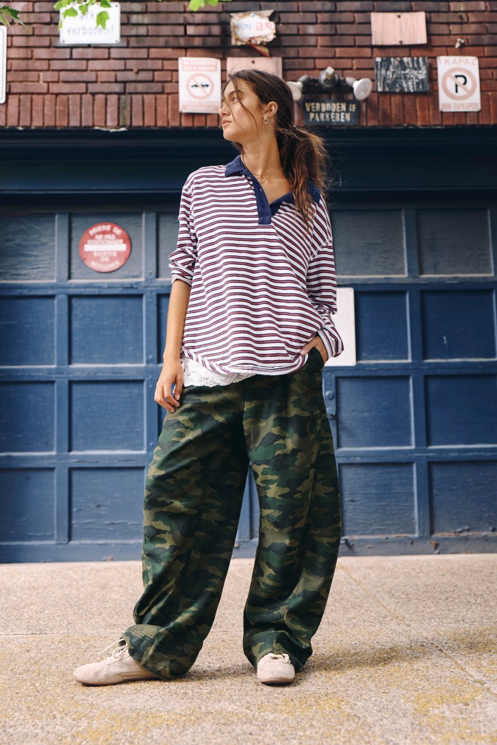 Woman wearing a striped long sleeve with camo pants.