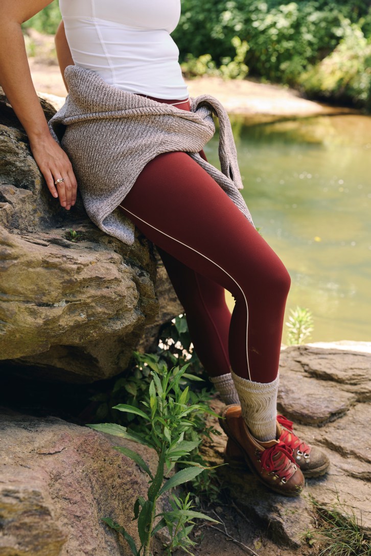 Woman wearing maroon leggings. 