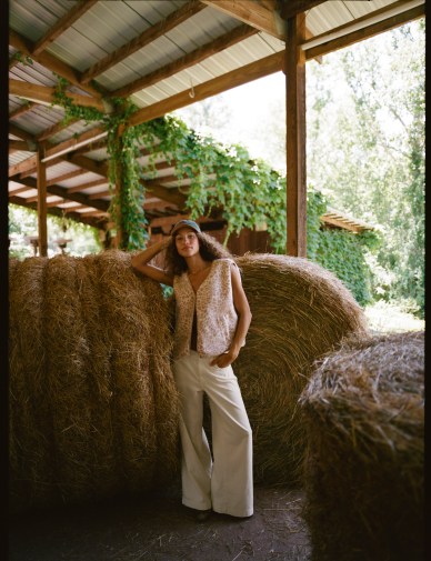 Woman wearing a matching set in front of hay barrels.