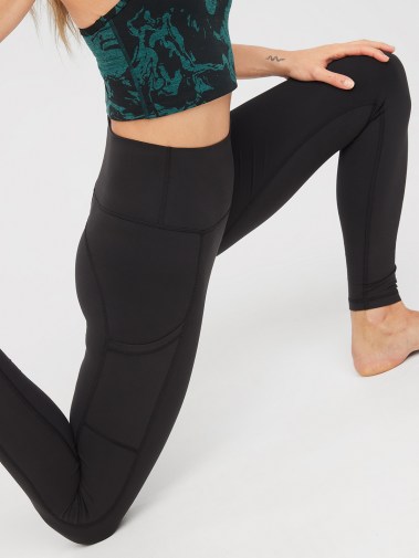 Woman squatting in Aerie leggings.